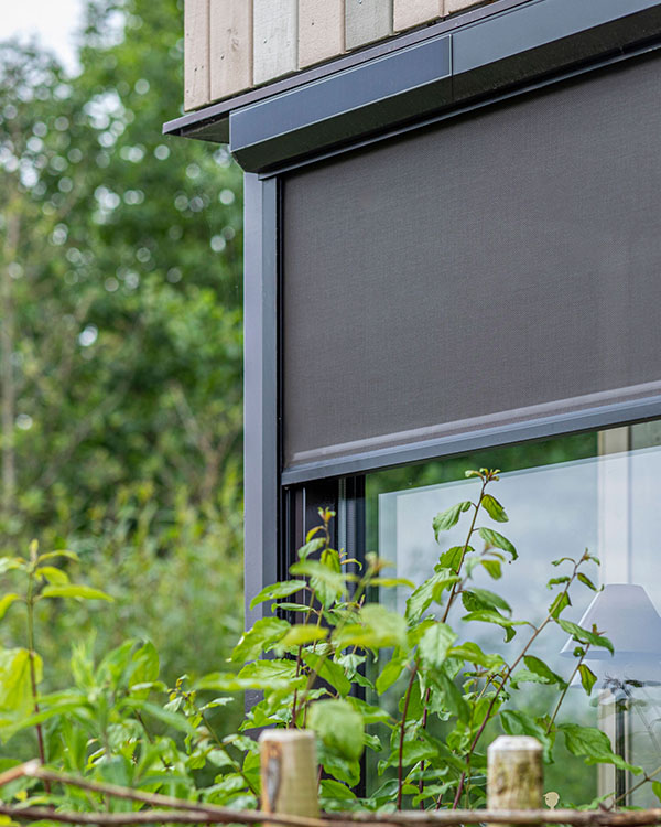Antraciet zip screen in cassette gemonteerd aan een houten gevel